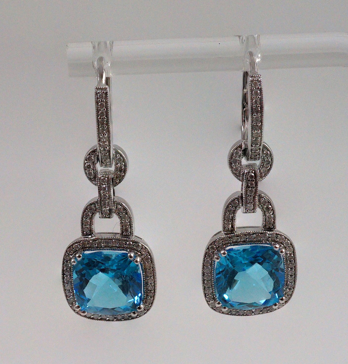 A modern pair of 14kt white gold, blue topaz and diamond chip set drop earrings